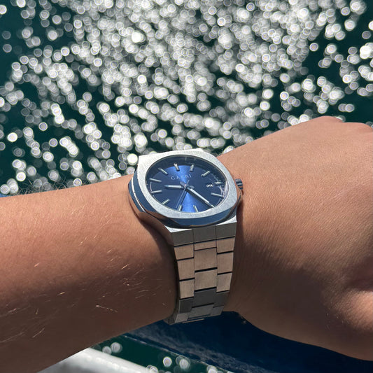 Relojes Capri Watches presentados como regalo perfecto para hombres, junto a cajas de regalo elegantes y comparativa visual con Daniel Wellington, Seiko, Fossil y Casio.